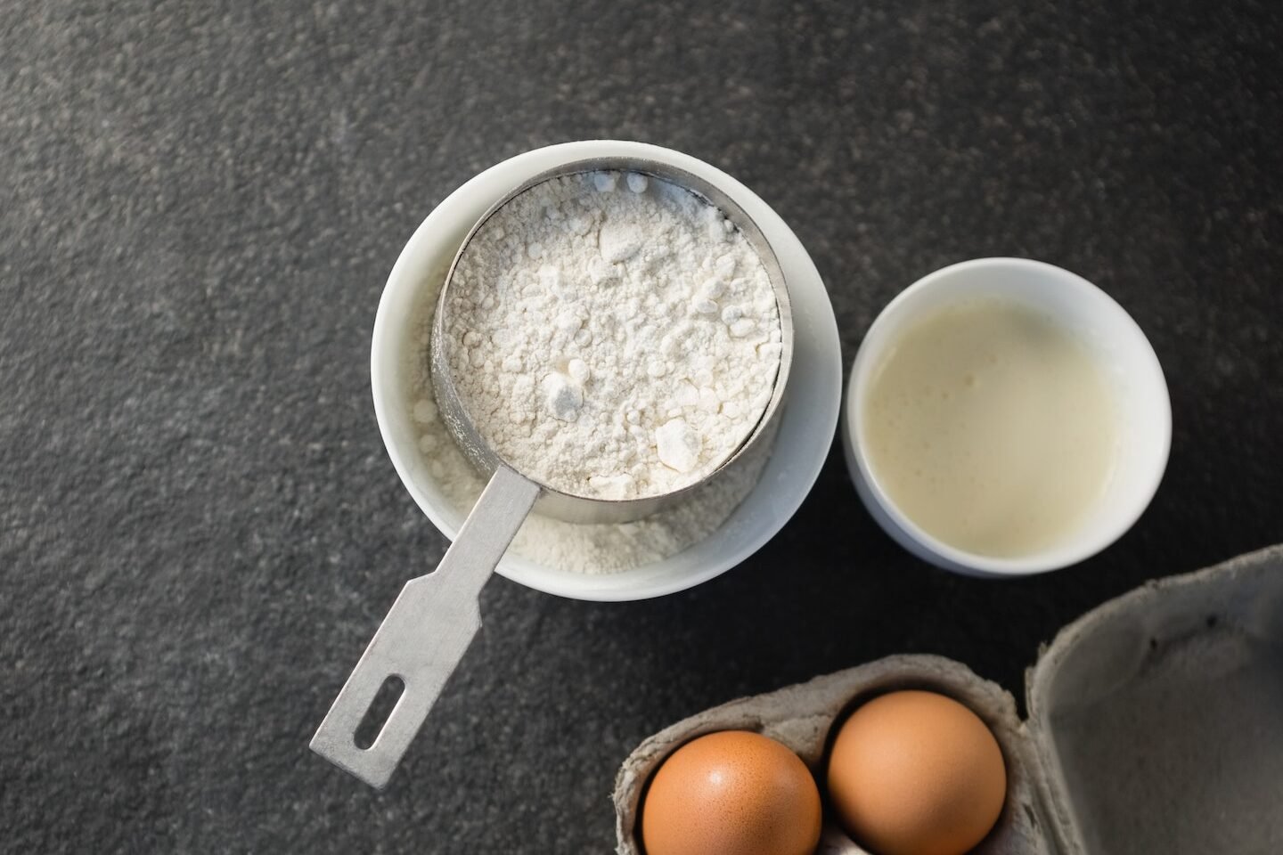 Directly above shot of flour and egg carton